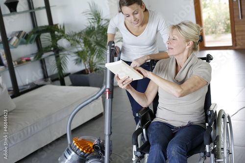 Fotografía Young woman helping disabled lady at home
