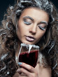 Portrait of young woman with snow make-up with a glass of wine.