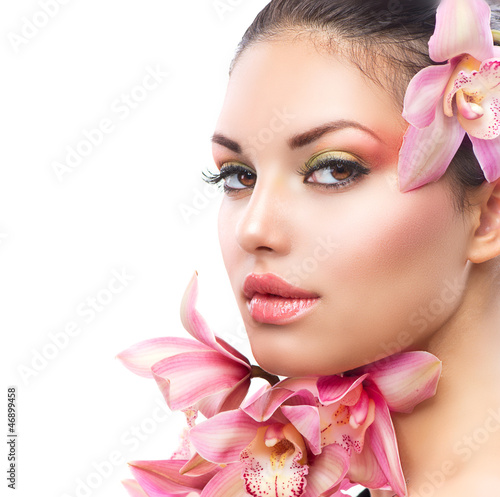 Fototapeta na wymiar Beautiful Girl With Orchid Flowers. Beauty Woman Face