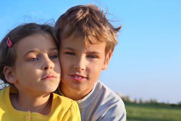 Wall Mural - Boy and girl together smile at background of blue sky