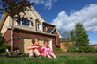 © Pavel Losevsky - Little girl and boy with biscuits sits on grass near cottage