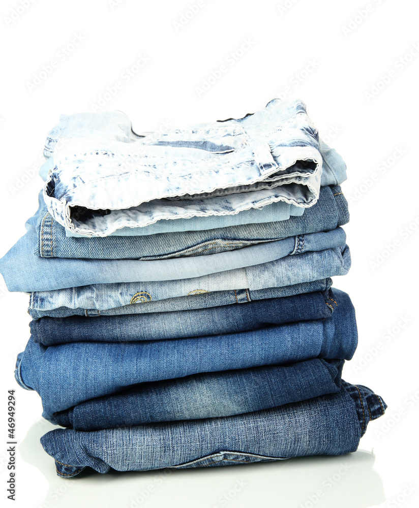 Lot of different blue jeans isolated on white