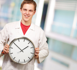 Portrait of a doctor holding a clock