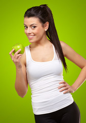 Wall Mural - Young woman holding and eating an apple