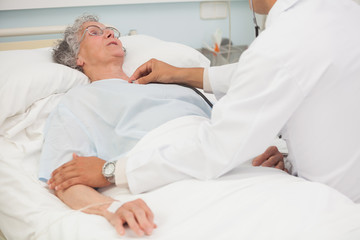 Wall Mural - Doctor listening to heart beat of elderly patient