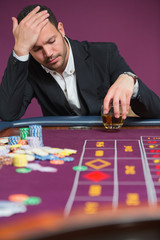 Man looking dejected at roulette table