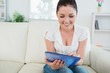 © WavebreakMediaMicro - Smiling woman using a tablet pc on the couch
