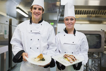 Two Smiling Chef's Showing Plates
