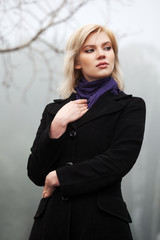 Young woman walking in an autumn foggy field