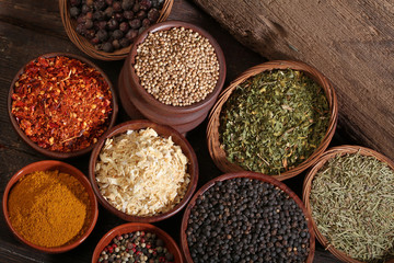 Wall Mural - Different bowls of spices over a wooden background