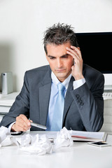 Wall Mural - Tensed Businessman Sitting At Desk