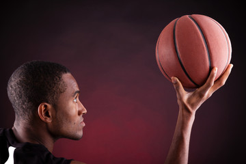 Portrait of a young male basketball player against black backgr