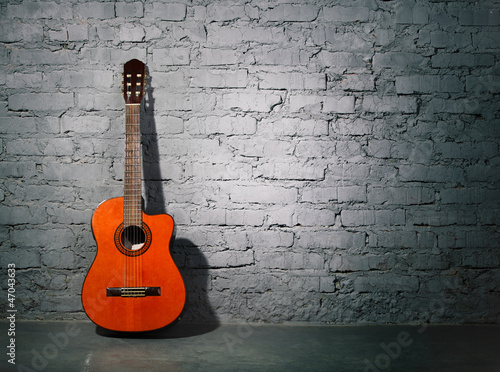 Obraz w ramie Acoustic guitar leaning on grungy wall