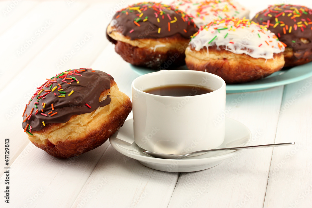 Tasty donuts on color plate on light wooden background