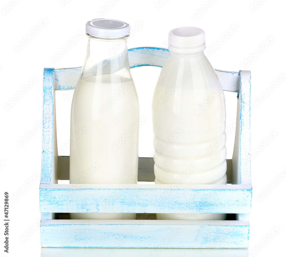 Milk in bottles in wooden box isolated on white