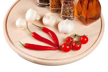 Mushrooms, peppers, tomatoes and spices on a cutting  board.