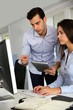 © goodluz - Office workers in front of desktop computer with tablet