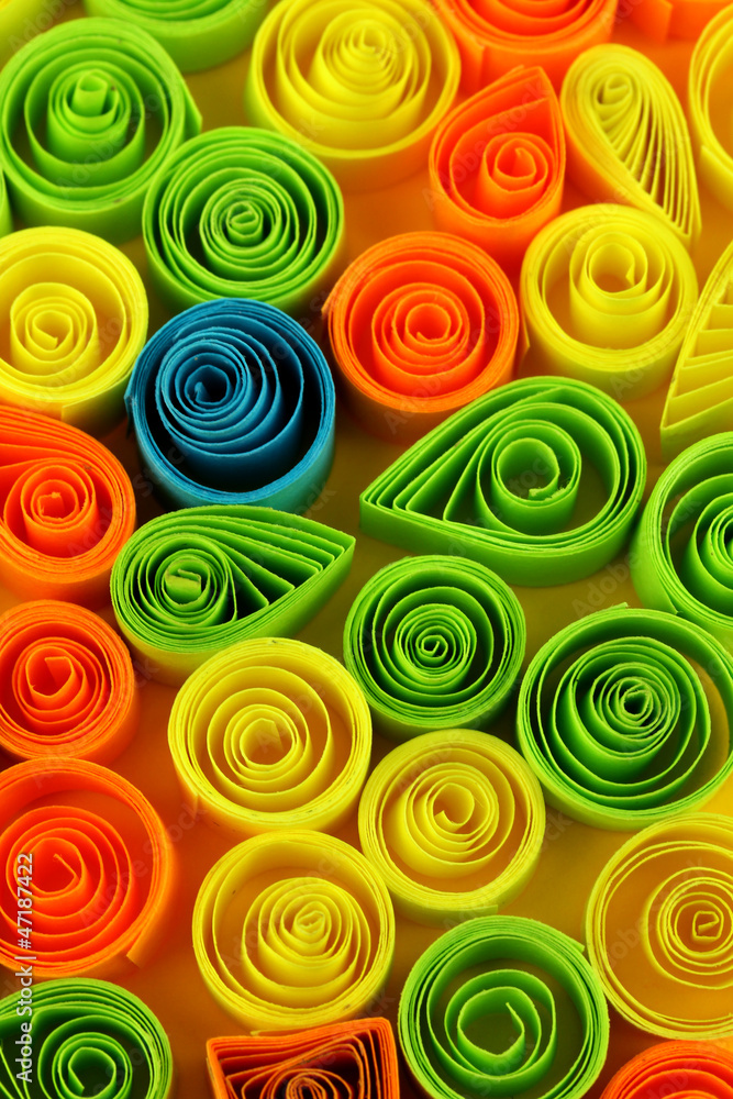 Colorful quilling on yellow background close-up