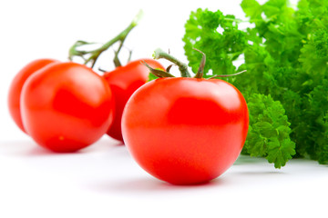 Wall Mural - Red tomato with parsley isolated on white background.