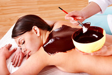 Woman Having Chocolate Facial Mask Apply By Beautician.