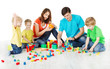 © inarik - Happy family. Parents with three kids playing blocks over white