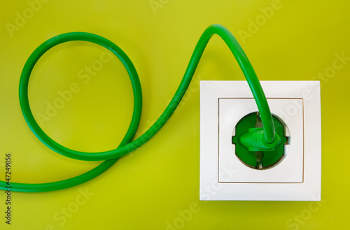 Fotografía Green power plug into white power socket