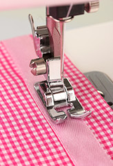 Wall Mural - Closeup of sewing machine working part with  pink cloth