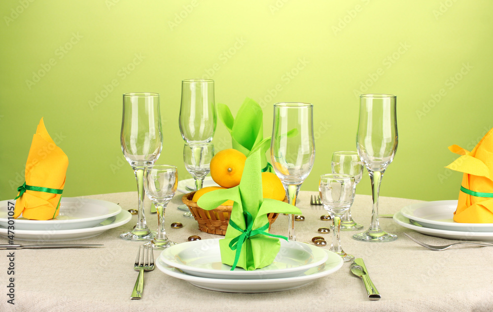 Table setting in green and yellow tones on color  background