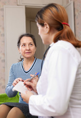 Wall Mural - mature woman complaining to doctor about feels