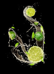 Leinwandbilder - Limes in water splash, isolated on black background