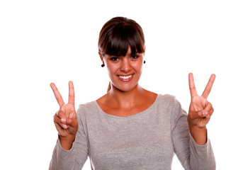 Young woman holding up fingers in victory sign