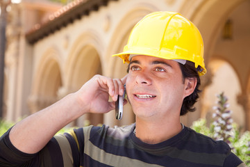 Wall Mural - Handsome Hispanic Contractor on Phone with Hard Hat Outside