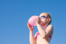 Little Girl Blowing Balloon