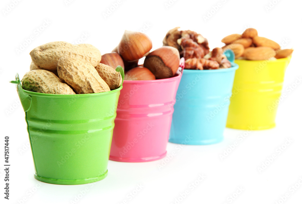 assortment of tasty nuts in pails, isolated on white