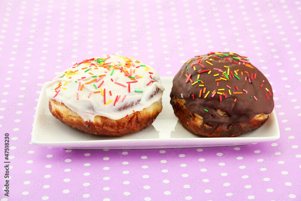 Tasty donuts on color plate on color background