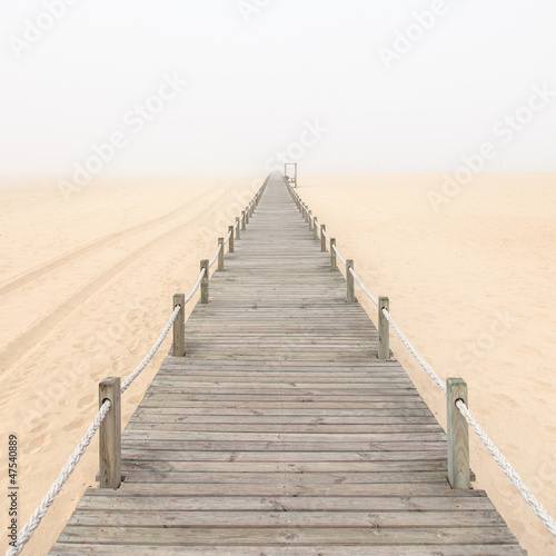 Fototapeta do kuchni Drewniana kładka na tle mglistego piasku plaży