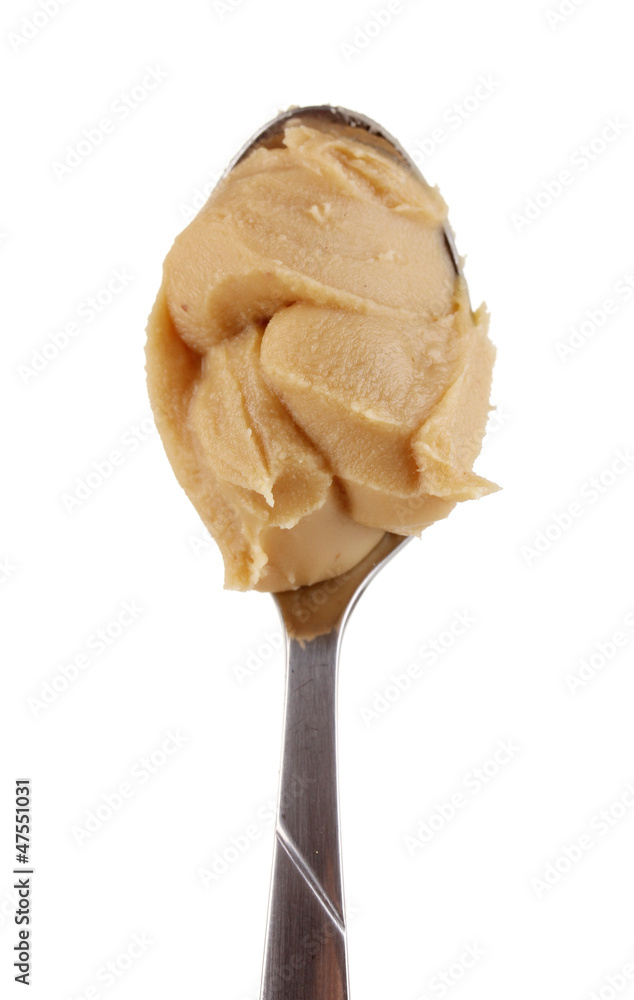 Delicious peanut butter in spoon isolated on white close-up