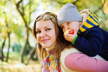 Young mother with her little son in autumn park