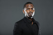 © ysbrandcosijn - Cool black american man in dark suit. Studio fashion shot.