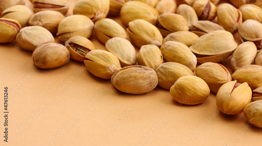 tasty pistachio nuts, on beige background