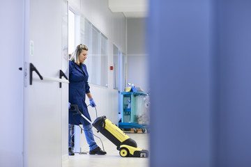 Women at workplace, professional female cleaner washing floor in