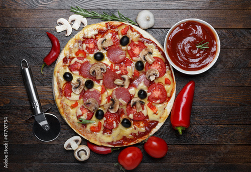 Naklejka samoprzylepna Gorąca pizza na prosty drewniany stół z składników i nóż