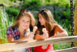 © stormy - Two happy girl friends eating ice cream outdoors