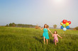 Mother and daughter running with multicolored balloons