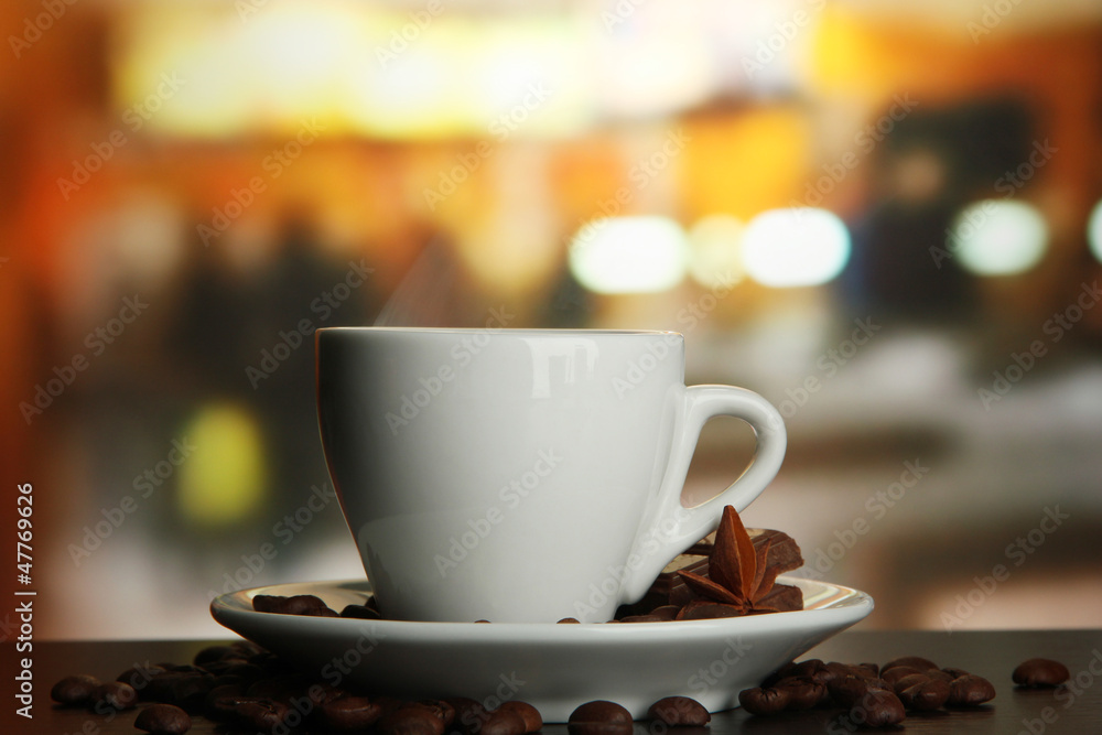 cup of coffee with beans on table in cafe