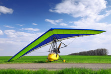 Motorized Hang Glider Over Green Grass