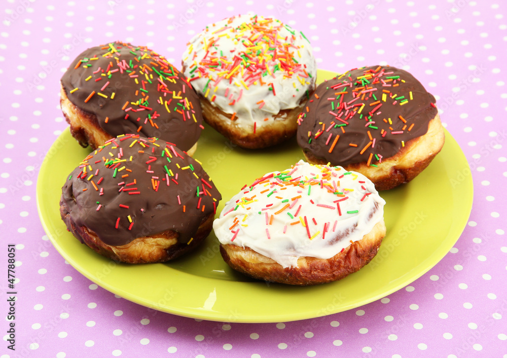 Tasty donuts on color plate on color background