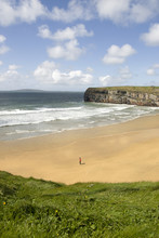 View Of Lone Man At Beach And Cliffs In Ballybunion