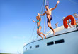 © goodluz - Young couple jumping in water from yacht