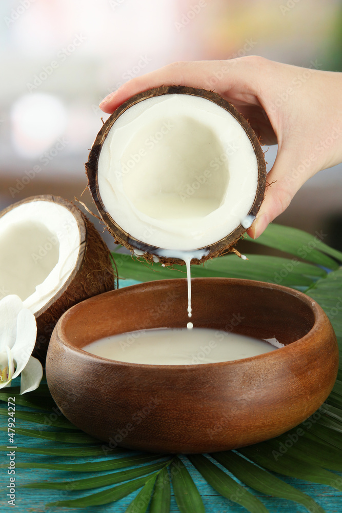 Coconut with leaves and flower, on blue wooden background